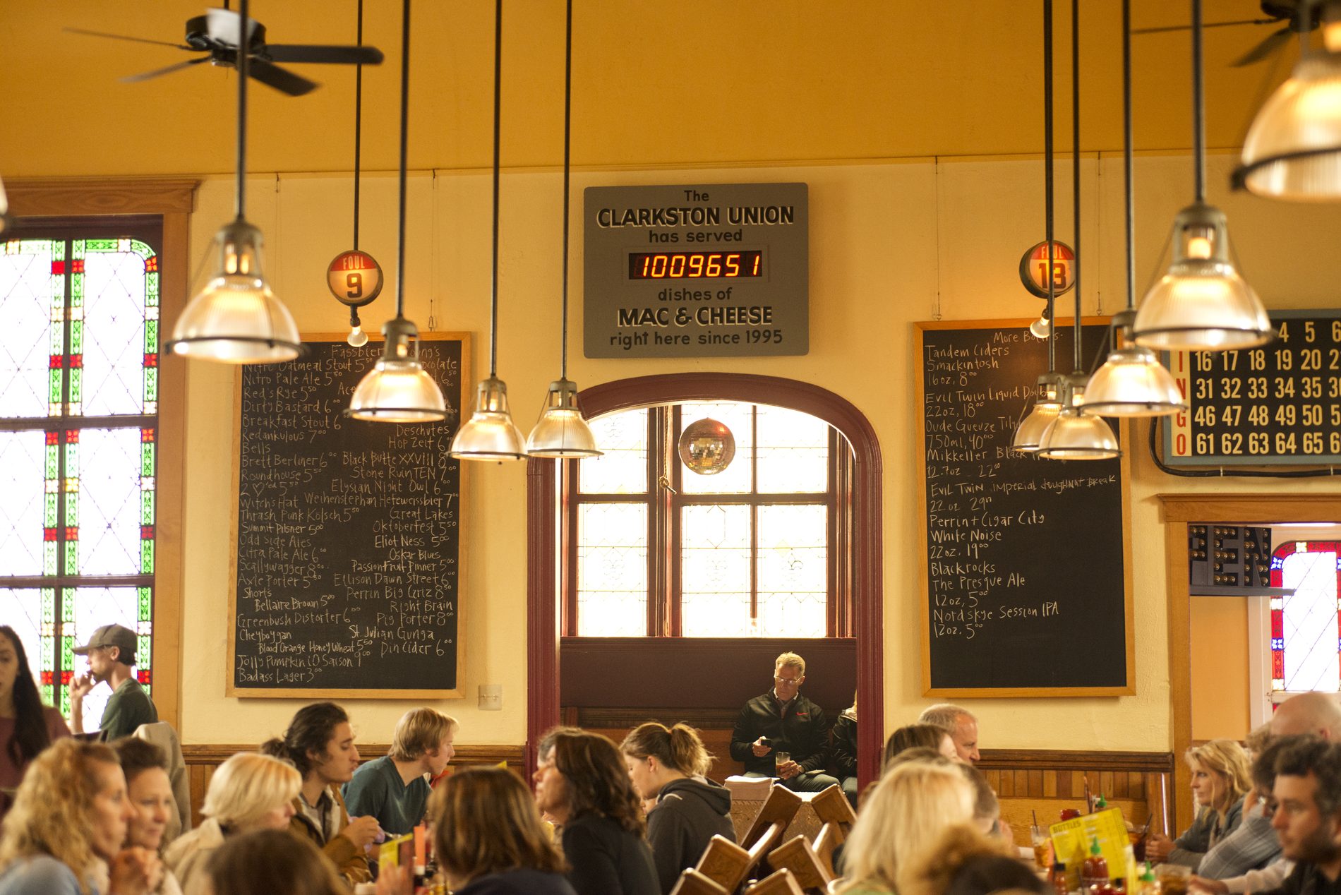 The dining room with chalkboards, hanging lamps and the mac and cheese counter above the arch