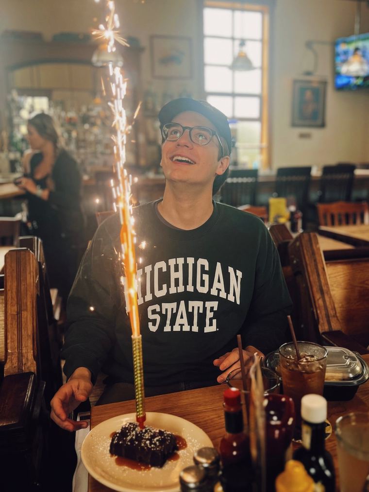 A birthday dessert arriving with a sparkler
