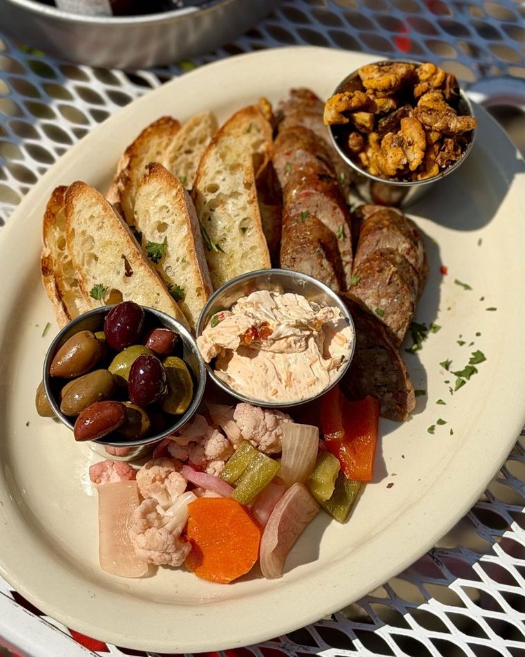 A catering board of crostini, olives and dips