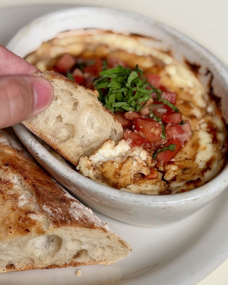 A baked bowl with flatbread to dip