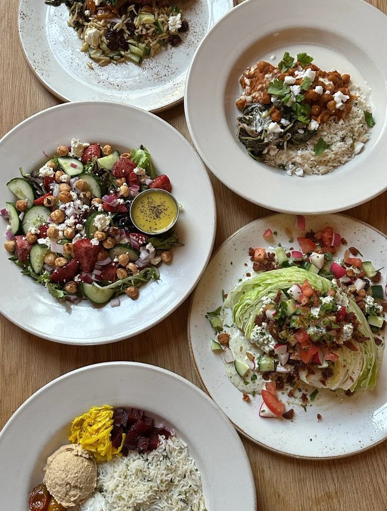 A spread of salads, rice bowls and small plates on a table